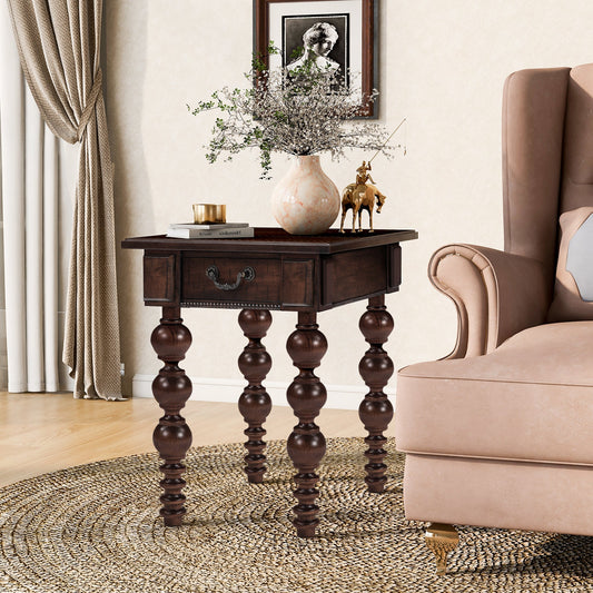 Espresso wood end table with drawer and turned spindle legs beside a sofa in a living room