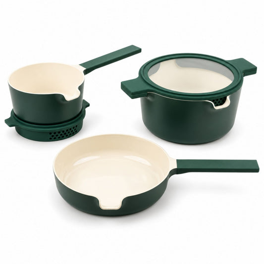 Green nesting ceramic nonstick cookware set stacked with glass strainer lids in a small kitchen