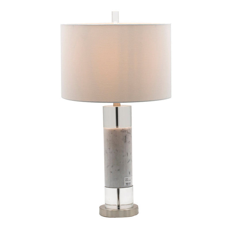White marble and clear acrylic cylinder table lamp with white drum shade on a living room side table