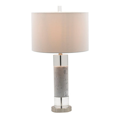 White marble and clear acrylic cylinder table lamp with white drum shade on a living room side table