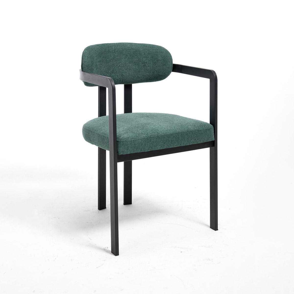 Two green upholstered dining arm chairs with curved backrests and black metal legs in a dining room