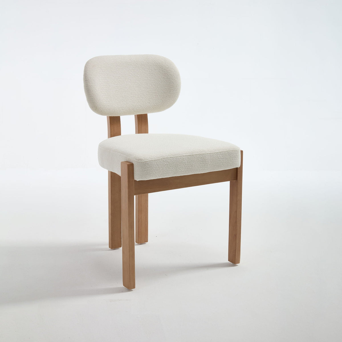 Two light blue upholstered dining chairs with ergonomic backrests and wood legs at a dining table