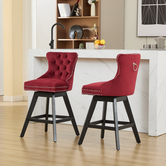 Two wine red velvet button tufted swivel bar stools with wood legs at a home bar