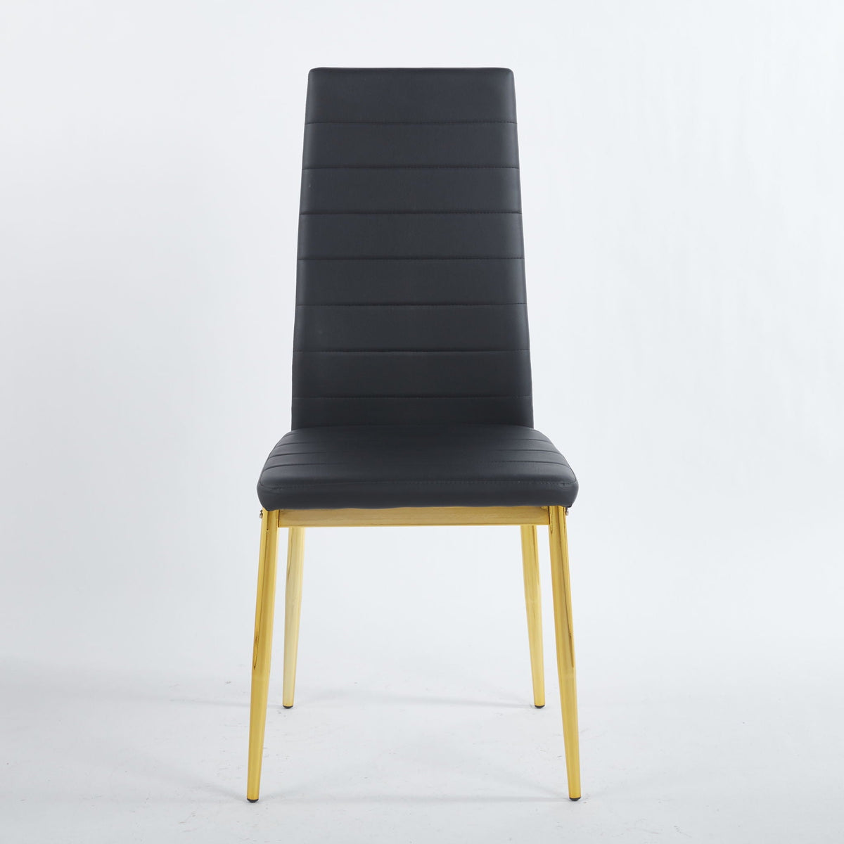 Four modern black faux leather dining chairs with metal frames and gold-accented legs around a table
