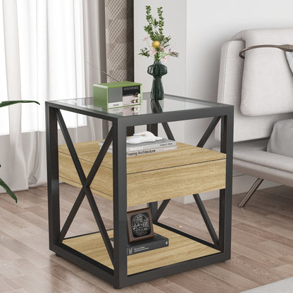 Modern natural wood end table with tempered glass top, drawer and X-frame beside a sofa