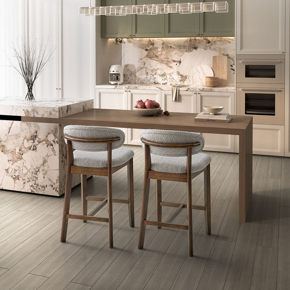 Two white-washed mid-century modern upholstered counter stools at a kitchen island