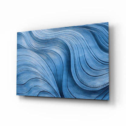 Blue painterly ocean waves glass wall art above a sofa in a serene modern living room