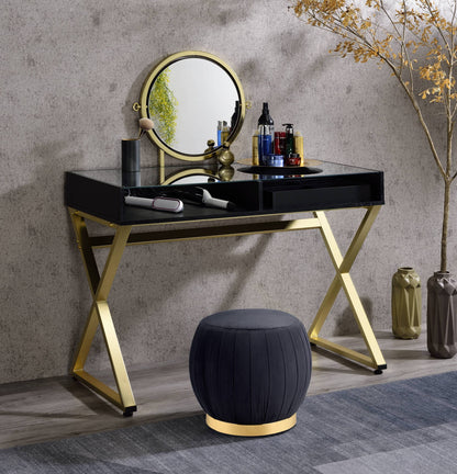Black and gold vanity desk with integrated mirror, jewelry tray and two drawers in a modern bedroom
