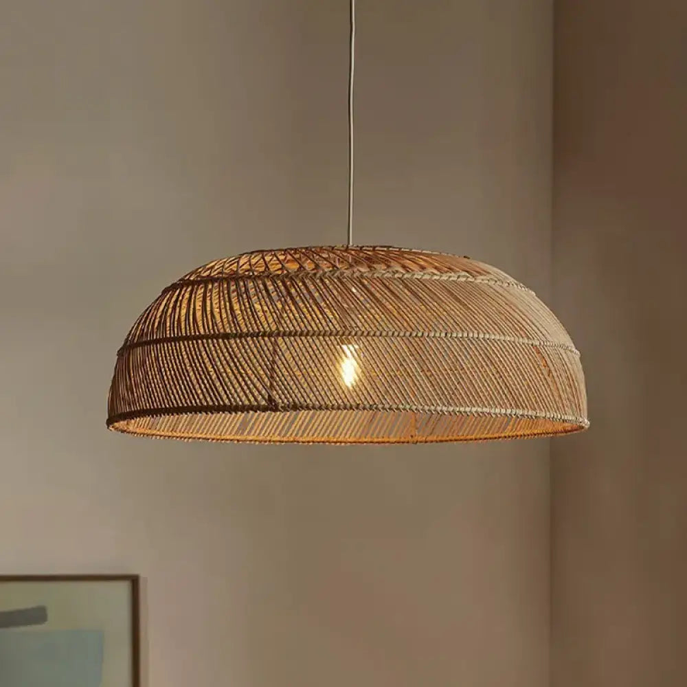 Handmade Chinoiserie flat rattan pendant light with a patterned shade over a dining table