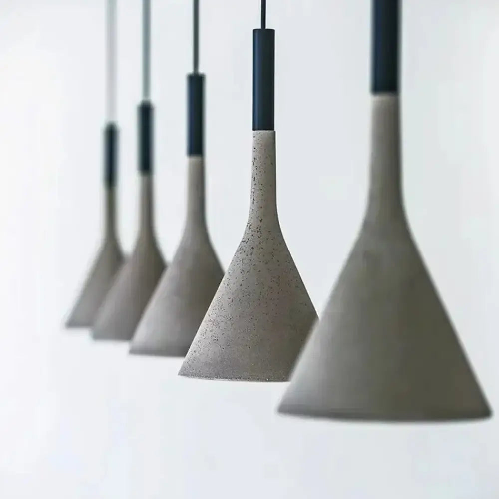 Cement concrete Nordic LED pendant light hanging over a wooden dining table in a modern room