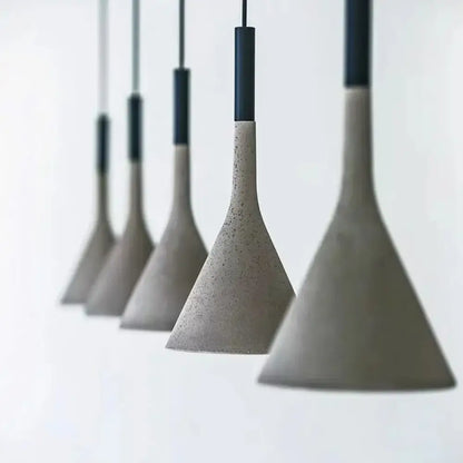 Cement concrete Nordic LED pendant light hanging over a wooden dining table in a modern room