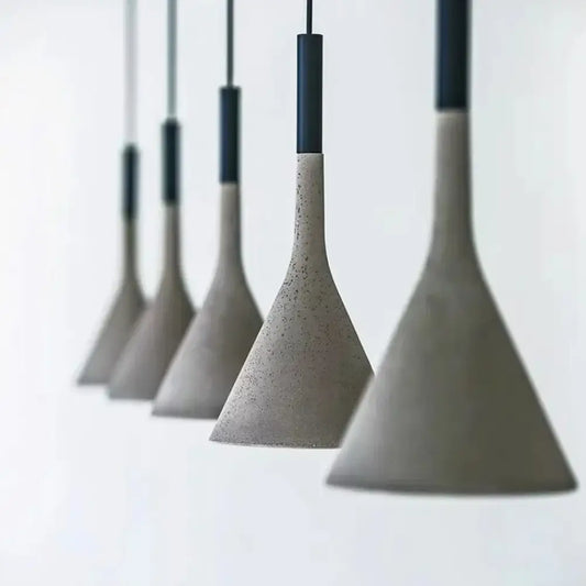 Cement concrete Nordic LED pendant light hanging over a wooden dining table in a modern room
