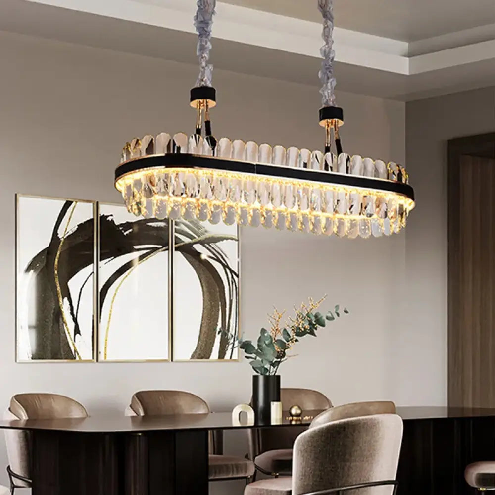 Oval crystal LED chandelier with black leather accents above a dining table