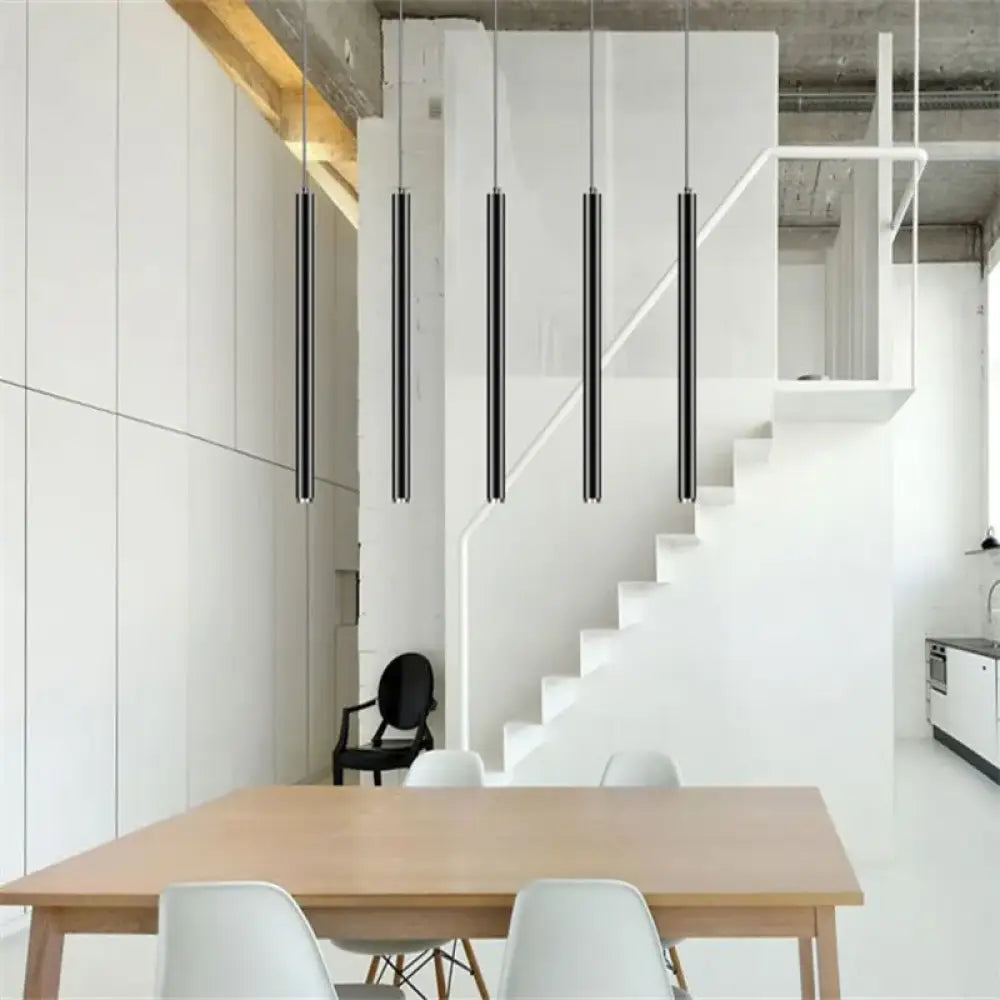 Row of black Ella Nordic long tube LED pendant lights hanging over a modern kitchen island