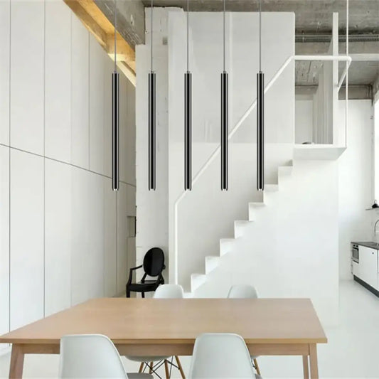 Row of black Ella Nordic long tube LED pendant lights hanging over a modern kitchen island
