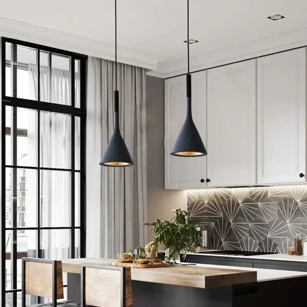 Modern metal Emma cord pendant light with a single shade hanging over a bedside table