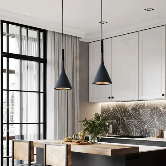Modern metal Emma cord pendant light with a single shade hanging over a bedside table