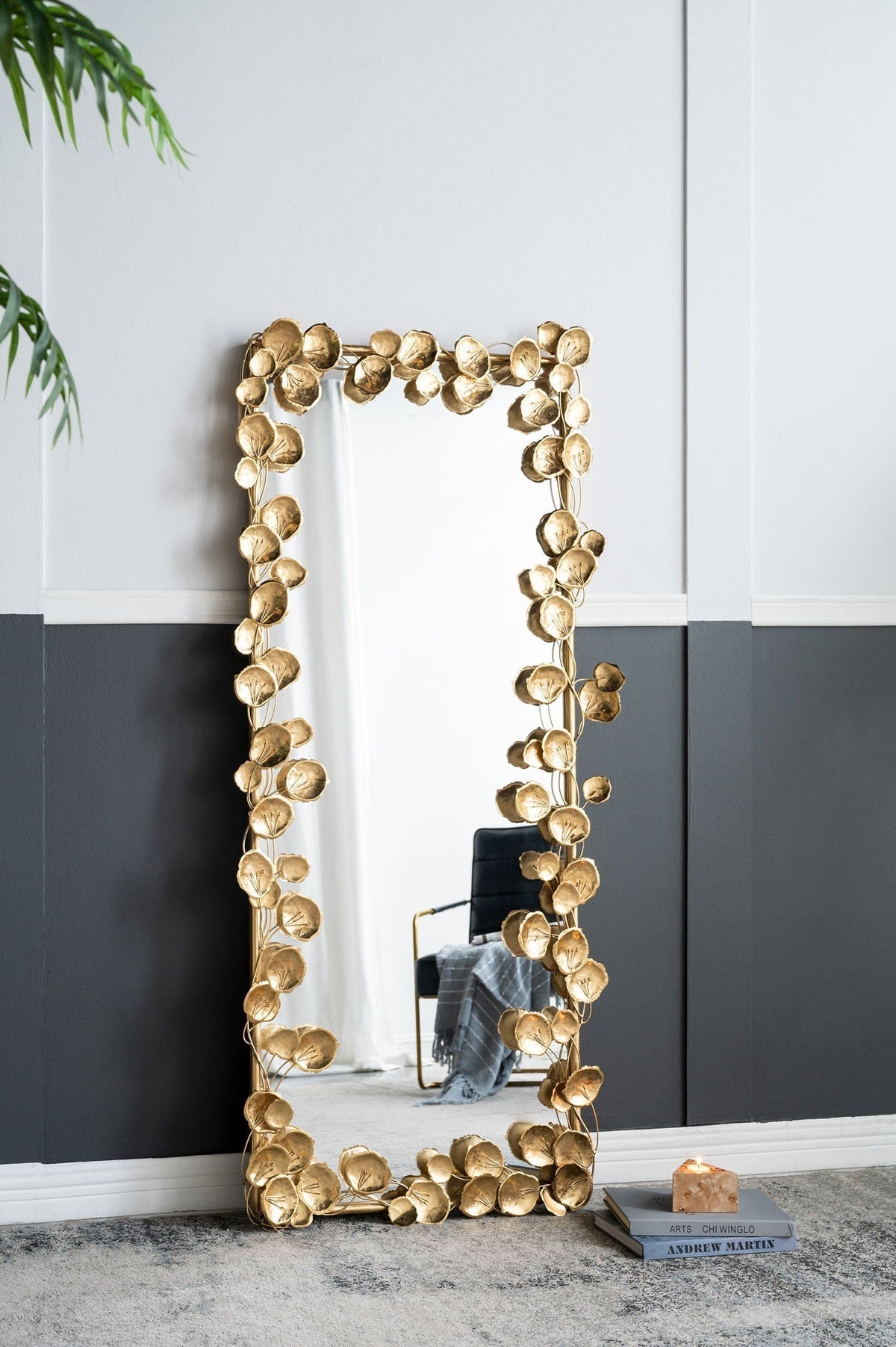 Full-length floor mirror with gold leaf iron frame leaning against a bedroom wall