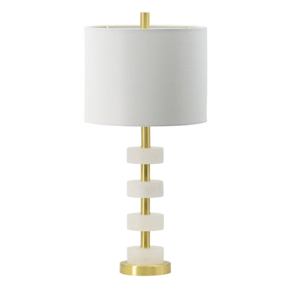 White marble table lamp with gold brass frame and white drum shade on a bedroom nightstand