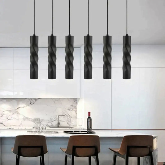 Black aluminum cylinder Freya LED pendant lights hanging above a kitchen island counter