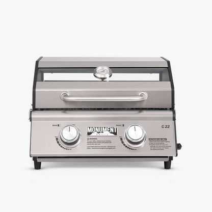 G22 stainless steel portable tabletop propane gas grill with locking lid at a campsite