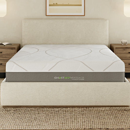 White GhostBed massage hybrid mattress with memory foam on a bed frame in a modern bedroom