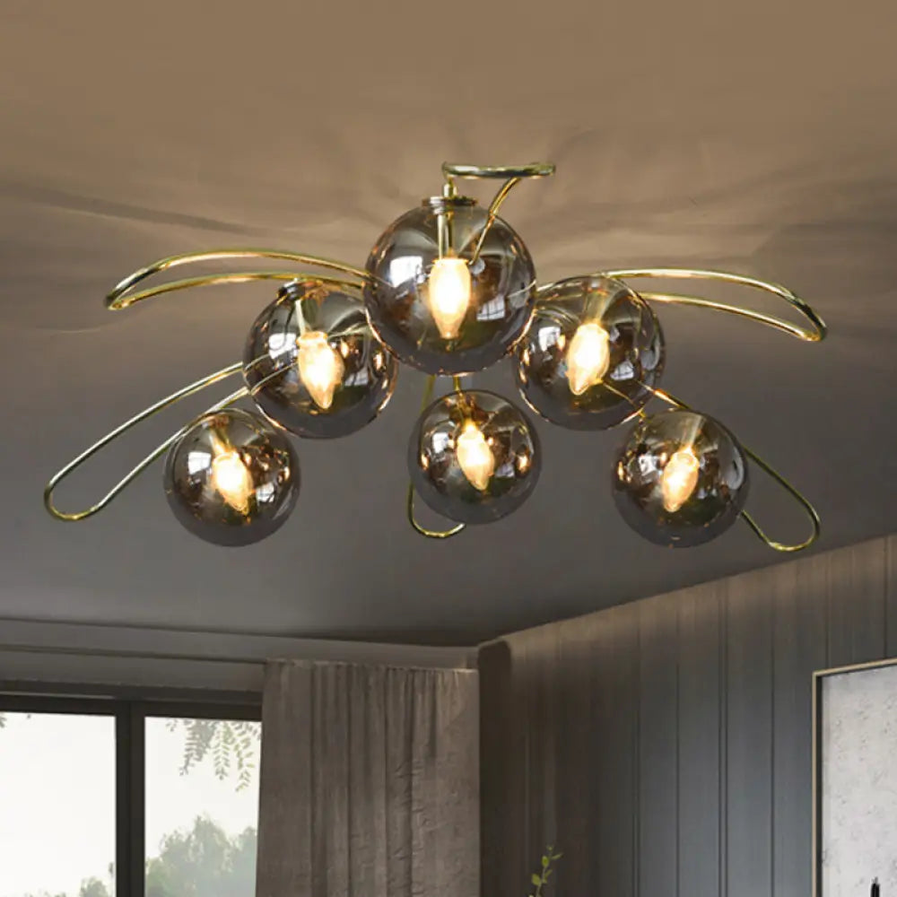Clara brass flush mount ceiling light with smoke gray glass globes in a modern living room