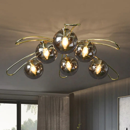 Clara brass flush mount ceiling light with smoke gray glass globes in a modern living room