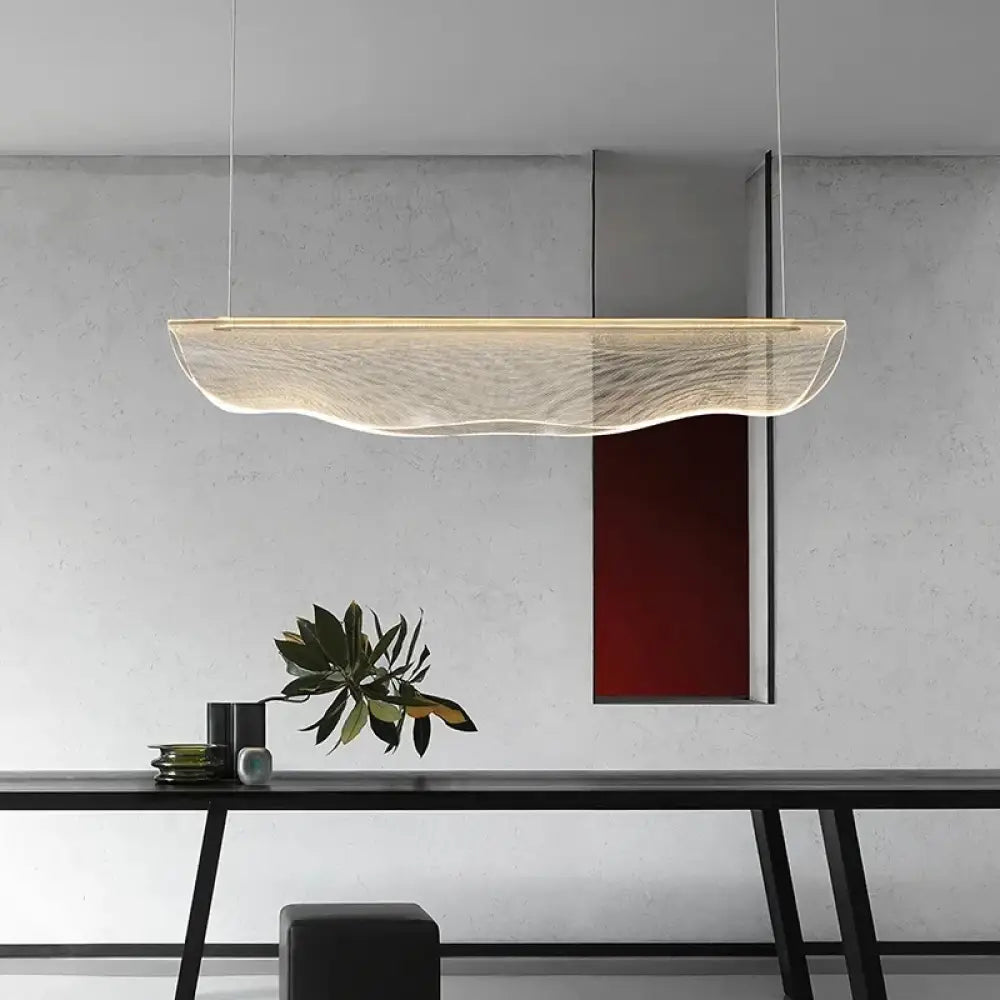 Contemporary irregular acrylic LED linear chandelier above a long dining table