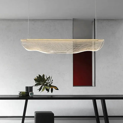Contemporary irregular acrylic LED linear chandelier above a long dining table