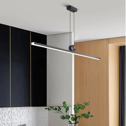 Black modern LED strip linear chandelier above a kitchen island