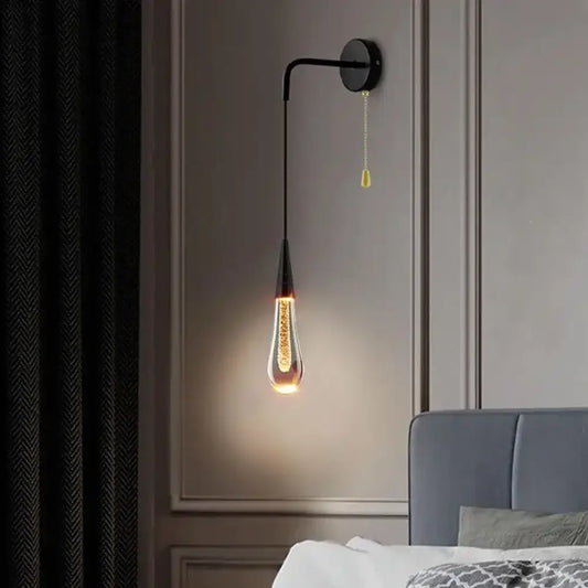 Gold LED crystal raindrop wall sconce as a bedside light in an elegant bedroom