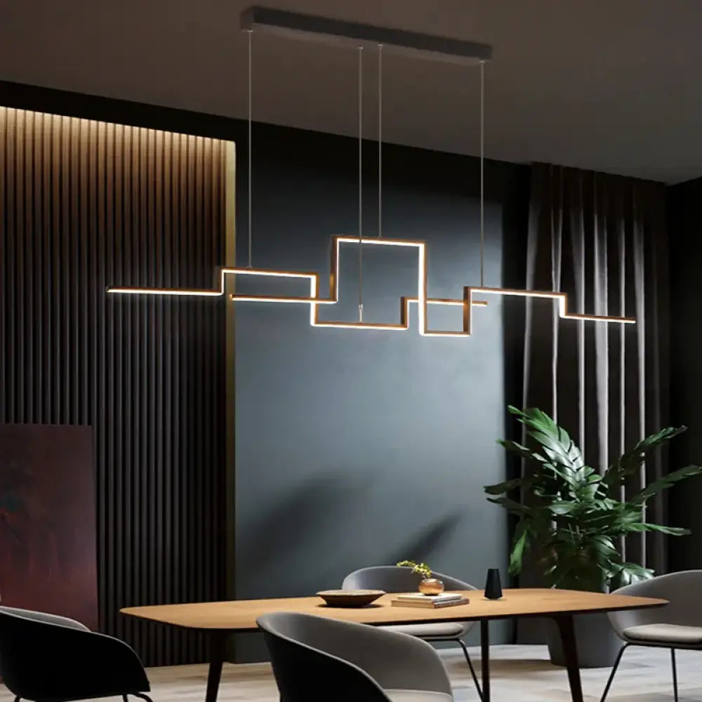 Black geometric LED linear pendant light hanging over a kitchen island in a modern home