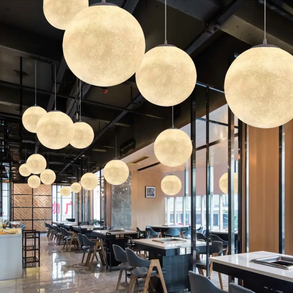 Textured wabi-sabi moon LED pendant light glowing above a dining table