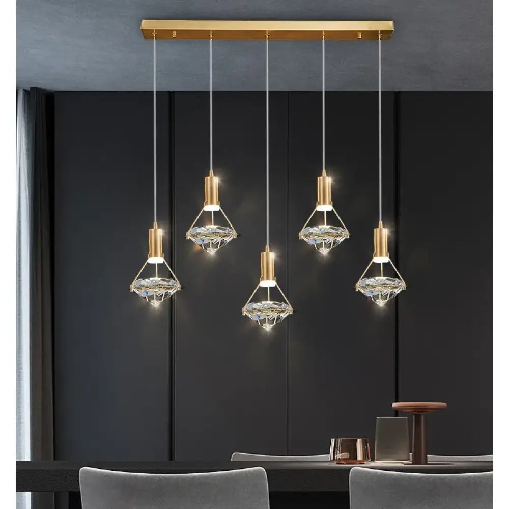 Modern crystal LED linear pendant light with sparkling shades hanging over a kitchen island