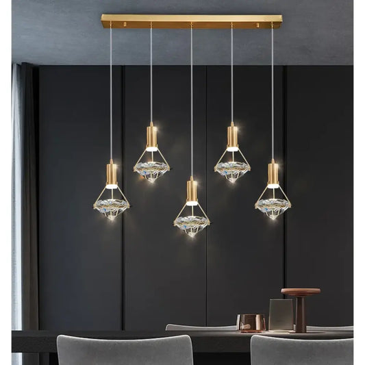 Modern crystal LED linear pendant light with sparkling shades hanging over a kitchen island
