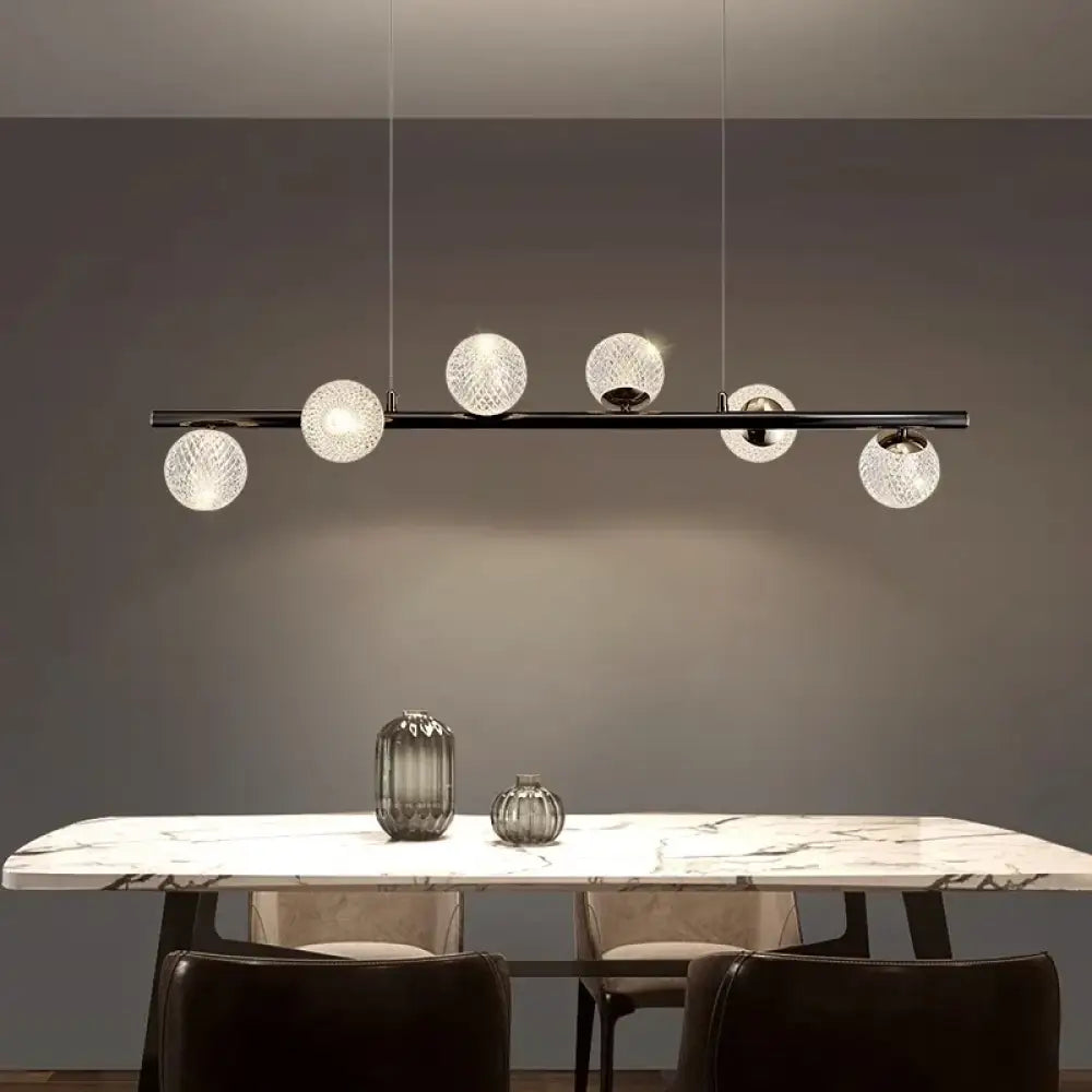 Sleek black modern LED pendant light glowing above a dining table in a contemporary dining room