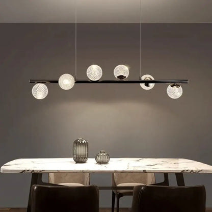 Sleek black modern LED pendant light glowing above a dining table in a contemporary dining room