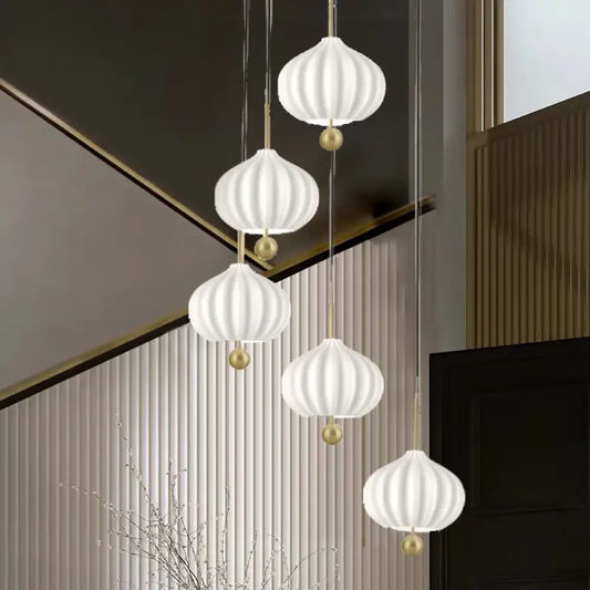Gold Nordic glass pumpkin LED chandelier with ribbed glass shades hanging in a staircase entry
