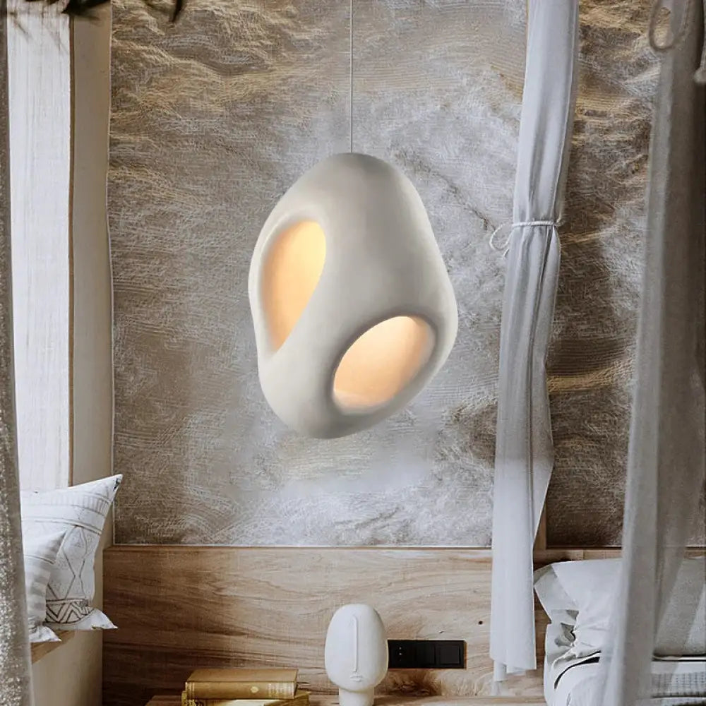 Sculptural Nordic Wabi-Sabi LED pendant light glowing over a bedside table in a calm bedroom