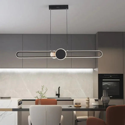 Minimalist black LED strip pendant light hanging above a kitchen island with remote dimming