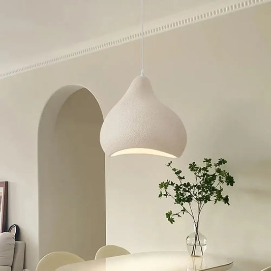 Cement gray Mira Wabi-Sabi pendant light hanging over a dining table in an understated room