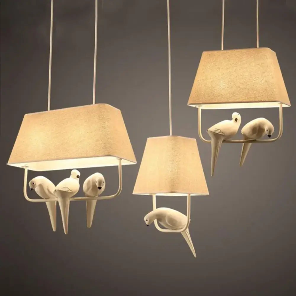 Modern bird pendant light with birdcage design above a dining table
