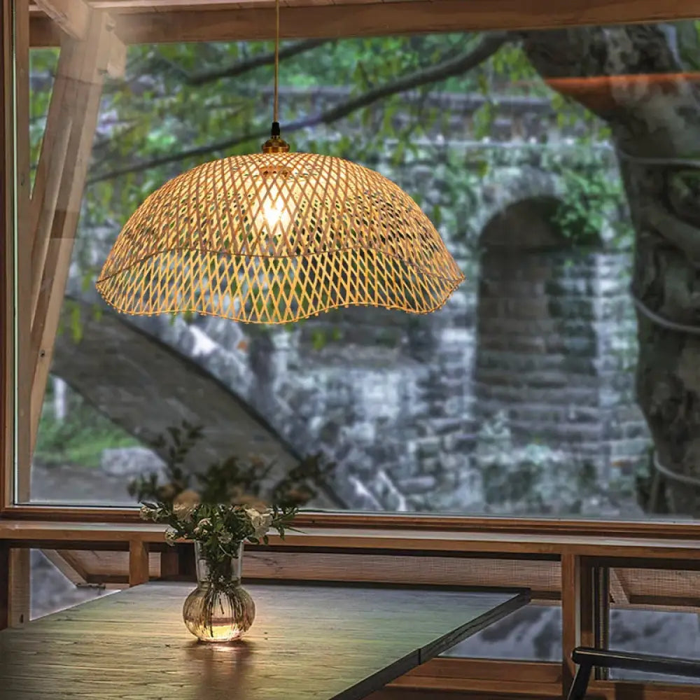 Hand-woven bamboo and rattan wicker pendant light glowing above a dining table