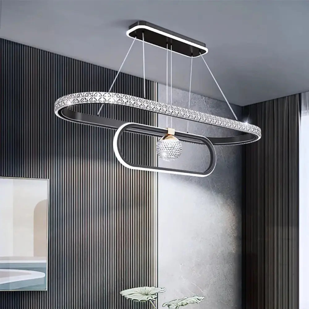 Black Nordic Signature chandelier glowing above a dining table in a Scandinavian dining room