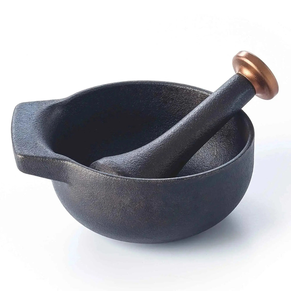 Enameled cast iron mortar and pestle with fresh herbs and spices on a kitchen counter