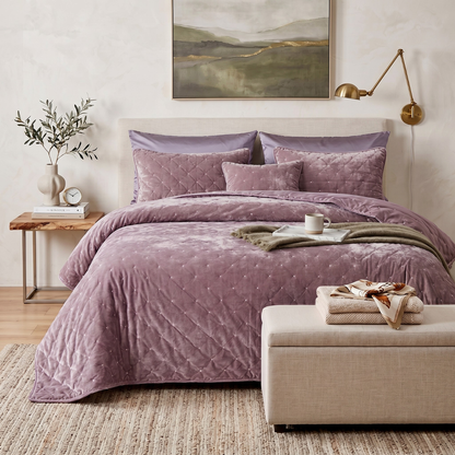 Mauve purple diamond tufted velvet quilt set with shams on a bed in a romantic bedroom