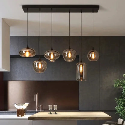 Smoky grey glass Nordic LED pendant lights hanging in a row over a kitchen island