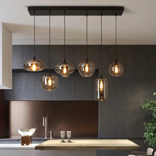 Smoky grey glass Nordic LED pendant lights hanging in a row over a kitchen island