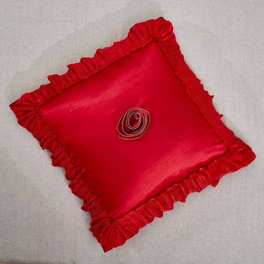 Bright red satin ruffle euro sham with floral embellishments on a glamorous bed